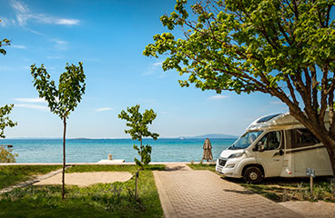 a van parked on a path by a beach