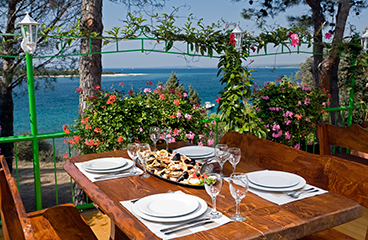 Een gedekte tafel in het restaurant Istrijanka met uitzicht op zee op de achtergrond