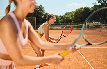 Ljudje igrajo tenis na teniškem igrišču v Naturističnem taboru Bunculuka