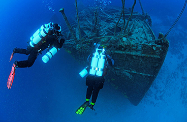 Twee duikers onderzoeken een scheepswrak