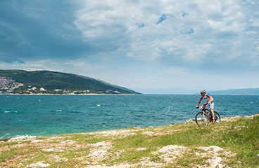 a person riding a bike on a rocky beach