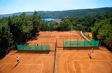 Ljudje igrajo tenis na teniških igriščih