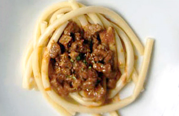 Gekochte Pasta (Makaruli) gewürzt mit Schweinefett und Zimt (Kanjel) serviert mit einer Sauce aus Fleisch, Tomaten, Petersilie und Knoblauch