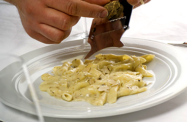 a person preparing pasta and truffles