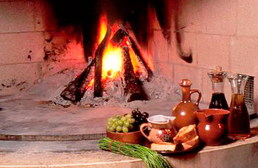 Vuur brandt in de vuurkorf met kleipotten voor Istrische soep ernaast