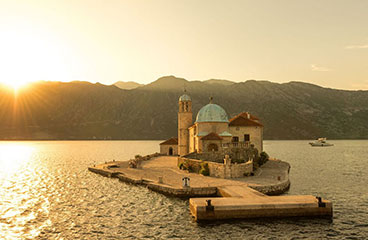 a body of water with mountains in the background