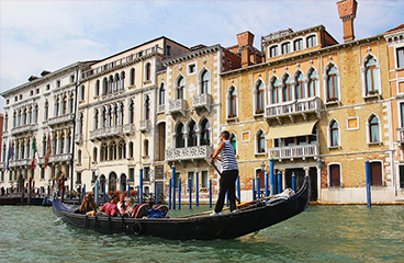 Skupina ljudi vozi se gondolom u Veneciji