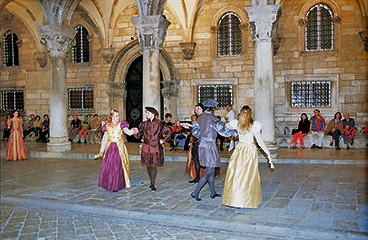 Mensen in middeleeuwse kostuums in het Sponza-paleis