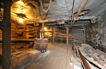 a room with a wood floor and a wood floor with a large metal object on it