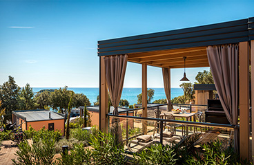 Prostorna pokrita terasa Premium kamping chaleta Bella Vista, ki gleda na morje in lahko sprejme do 3 osebe.