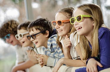 Otroci s 3D očali naslonjeni na ograjo