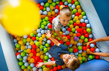 a couple of kids playing in a ball pit