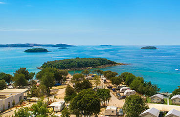 Panoramablick auf den Strand und die Campinghütten im Istra Premium Camping Resort, das ruhige Unterkünfte am Meer bietet.