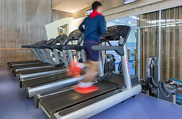 Muškarac trči po stazi u fitness centru