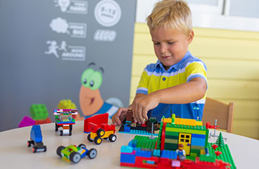 Mali dječak se igra s igračkama automobila u Maro klubu