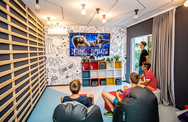 Groep tienerjongens speelt op een console in de Game Lounge
