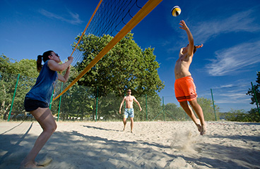 Young people playing beach volleyball