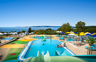 Kinderwaterpark en zwembad met twee glijbanen en verschillende soorten sproeiers