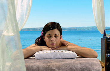 Frau entspannt auf einer Massagebank in der Nähe des Meeres