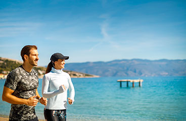 Coppia che fa jogging accanto al mare Adriatico