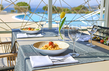 Miza s testeninami spaghetti v Ristorante Oliva s pogledom na morje ob zunanjem bazenu