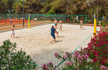 a group of men playing volleyball on a beach