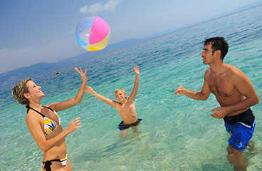 a group of people playing with a ball in the water