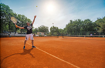 Dva muškarca igraju tenis na sunčan dan