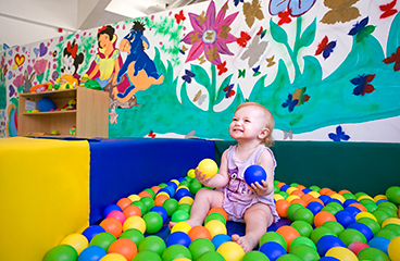 Baby spielt dank des Babysitting-Dienstes des Lanterna-Camps in einem Kinderballbecken