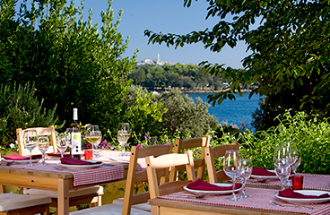 Zwei Tische im à la carte Restaurant im Premium Camping Resort mit Meerblickterrasse