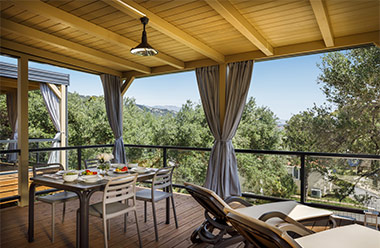 a table with chairs and a view of trees and mountains
