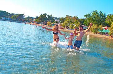 Obitelj koja se igra u plitkim vodama stjenovite plaže