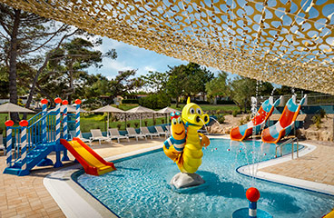 Kinder-Wasserpark mit zwei Wasserrutschen und lustigen Sprinklern