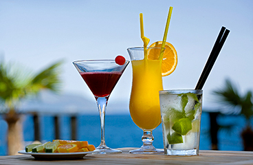 Kleurrijke cocktails in het restaurant, cocktail & lounge bar Pharos met de zee op de achtergrond
