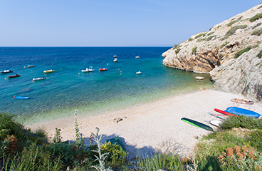 Pogled iz zraka na romantično prodnato plažo s kamnitimi območji za sončenje