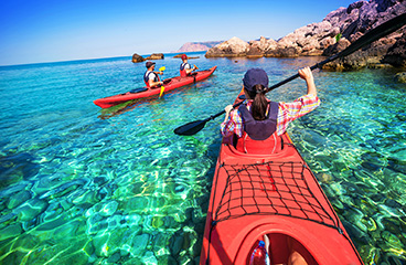 Un gruppo di persone fa kayak vicino alla costa rocciosa del mare Adriatico
