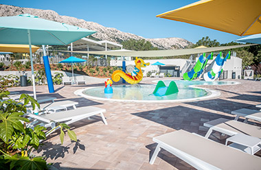 Parco acquatico per bambini con scivoli, spruzzatori d'acqua e piscina relax