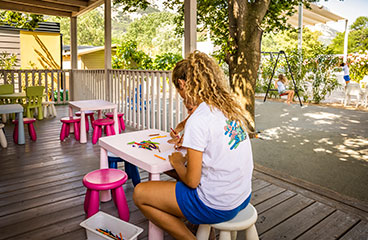 a group of children sitting at a table outside